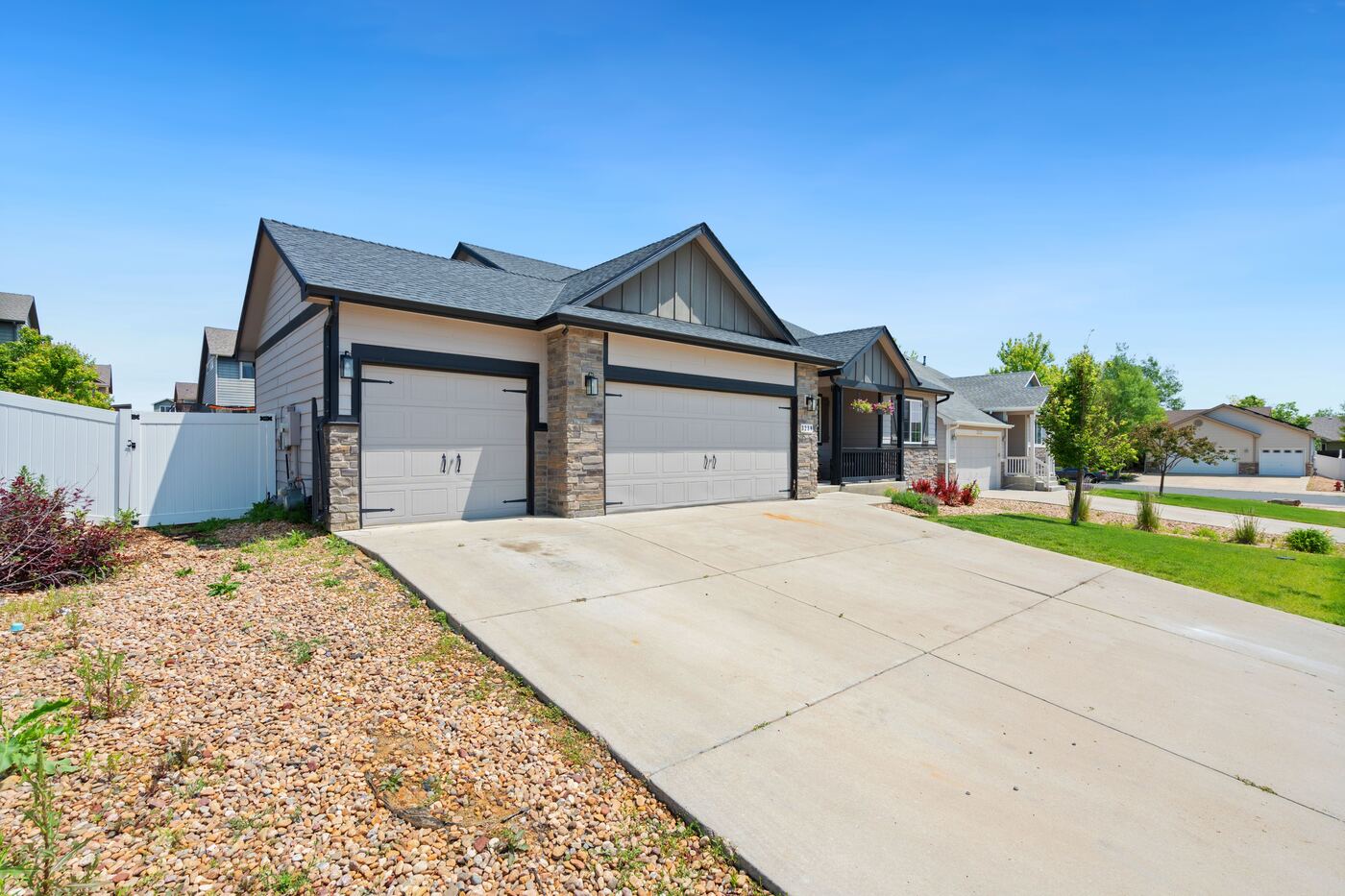 A newly built single-story home with a three-car garage and fresh landscaping